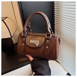 Gros plan détaillé du sac seau vintage en cuir marron avec pendentif cœur argenté