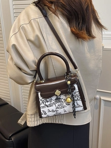 Fashionable brown leather and printed fabric crossbody bag with gold clover clasp detail