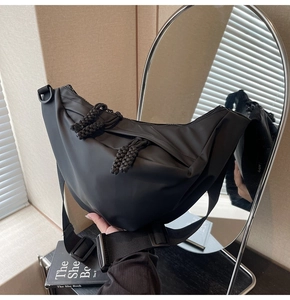 Detail einer schwarzen Nylon-Halbmondtasche mit dickem geflochtenem Seil-Reißverschluss
