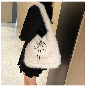 Détail d'un sac à bandoulière en fausse fourrure blanche avec nœud décoratif en cordon noir