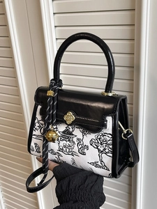 Contrast panel crossbody bag with landscape print and cloud buckle held by hand