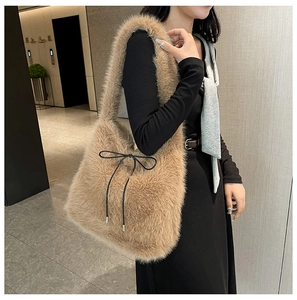 Détail du sac cabas en peluche marron doux avec un nœud noir décoratif et texture