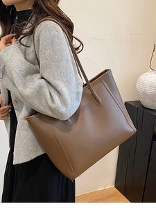 Minimalist brown faux leather tote bag with long shoulder straps for daily commuting