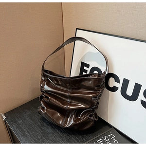 Dettaglio borsa hobo vintage in pelle verniciata marrone scuro con trama a pieghe