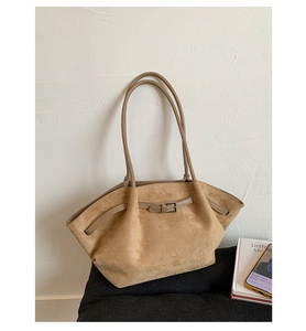 Close-up of khaki suede tote bag with belt buckle detail and soft handles