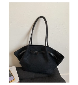 Detail view of large matte black tote bag with metal buckle strap and fan-shaped structure