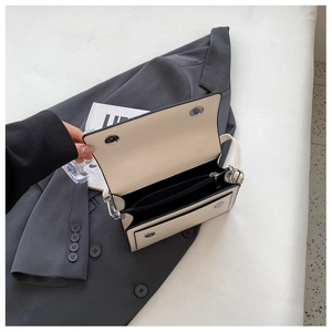 Detail of off-white PU leather bag showing magnetic closure and black interior lining