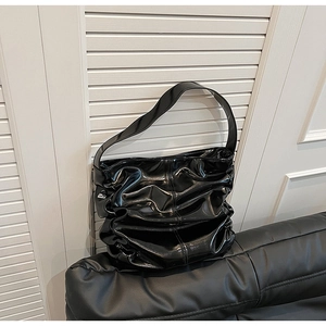 Vista dettagliata della borsa a spalla nera lucida con elegante trama a pieghe