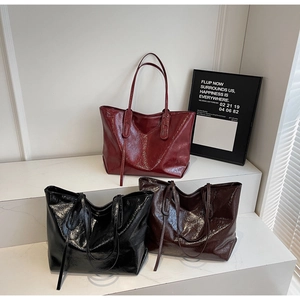 Detailed macro view of large tote bags in burgundy, black and dark brown oil wax leather