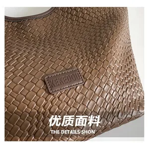 Dettaglio della trama in pelle intrecciata testa di moro con logo rettangolare sulla borsa
