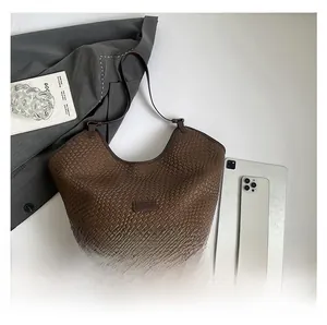 Flat lay di borsa tote in pelle intrecciata marrone con iPad e accessori per ufficio