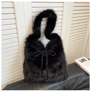 Détail d'un sac cabas en fausse fourrure noire avec un nœud décoratif en cuir fin