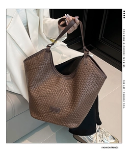 Dettaglio della trama in pelle intrecciata marrone e del logo sulla borsa vintage