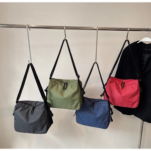 Detailed view of checkered canvas tote bags in grey, green, blue and red on hangers