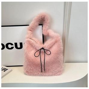 Détail du sac cabas en peluche rose avec un nœud noir et une texture douce en fausse fourrure