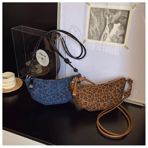 Dettaglio di borse croissant leopardate in blu e marrone con tracolla in pelle annodata