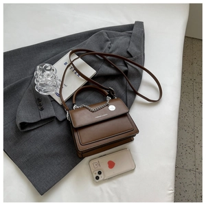Top view of brown PU leather crossbody bag with silver chain and fashion text detail
