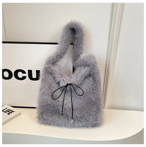 Gros plan d'un sac cabas en peluche grise avec un nœud en cordon noir et embouts argent