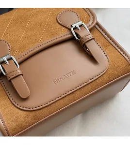 Close-up of brown vintage bag with quilted stitching and metal buckle details