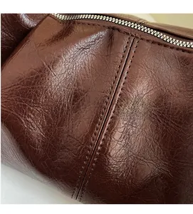 Detail of dark brown leather texture with silver zipper and precise double stitching