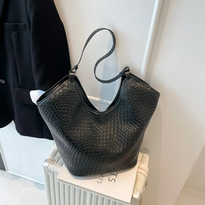 Dettaglio della trama in pelle intrecciata e tracolla della borsa tote nera da ufficio