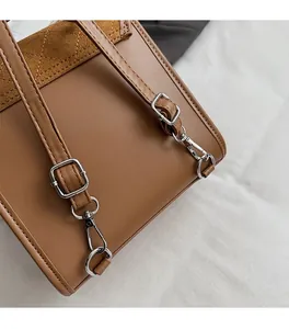 Detail of premium silver metal hardware and adjustable strap on a brown leather backpack