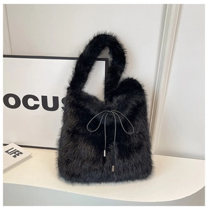 Détail du sac fourre-tout en fausse fourrure noire avec nœud coulissant et anse peluche