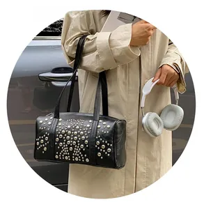 Close-up of black leather Boston bag with silver rivet studs and twin shoulder straps