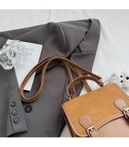Detail view of retro brown crossbody bag with suede-like diamond quilting and smooth texture