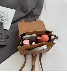 Internal view of brown leather backpack showing capacity for phone, umbrella and lipstick