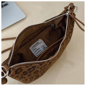 Dettaglio dell'interno della borsa leopardata con tasca a zip e fodera in tessuto