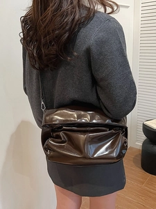Borsa a tracolla vintage marrone scuro lucido con pieghe mostrata su una modella