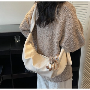 Detail of cream large hobo bag with textured leather and cute plush pendant charm
