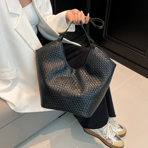 Dettaglio della trama in pelle intrecciata e della toppa con logo su questa borsa nera