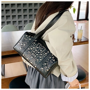 Detail view of black faux leather shoulder bag with silver studs and rectangle structure