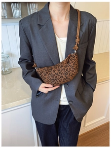Dettaglio borsa a mezzaluna leopardata vintage con tracolla in pelle marrone annodata