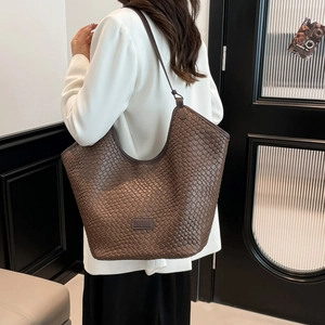 Dettaglio ravvicinato della trama intrecciata marrone scuro di una borsa a spalla
