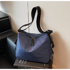 Detail of blue plaid nylon crossbody bag with adjustable strap and dual metal zippers