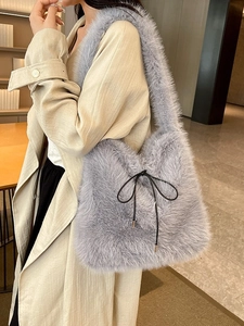 Sac fourre-tout en peluche gris clair avec nœud noir porté par un mannequin
