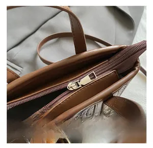 Détail d'un sac marron à texture tressée avec une fermeture éclair dorée