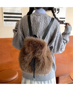 Detail of plush brown backpack with black drawstring closure and soft faux fur texture