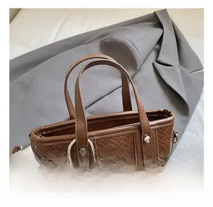 Vue détaillée d'un sac à main tressé marron foncé avec boucle argentée et perles en bois