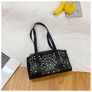 Detailed top view of black leather pillow bag with silver studs and long shoulder straps