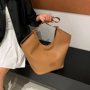 Dettaglio della trama della borsa tote marrone con motivo a rilievo e logo KEKEDOU