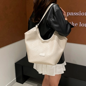 Borsa hobo intrecciata crema retrò abbinata a una giacca di pelle per un look autunnale chic