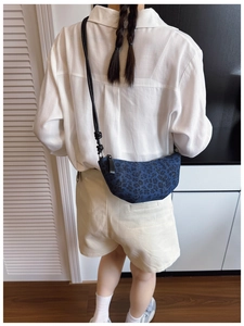 Dettaglio della trama denim leopardata e della forma a mezzaluna della borsa a tracolla