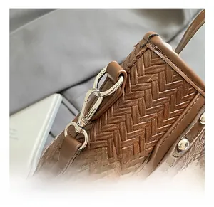 Gros plan sur la texture tressée marron foncé avec crochets en métal et coutures