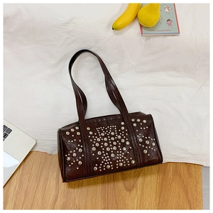 Detail shot of vintage dark brown leather bag with metallic rivet decorative patterns