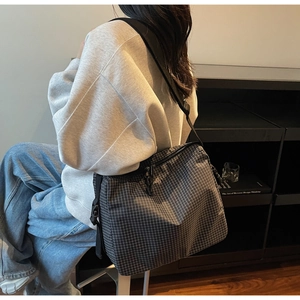 Detail showing the adjustable shoulder strap and fine black and white checkered fabric pattern