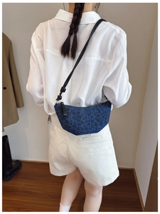 Dettaglio della borsa a mezzaluna in denim blu con stampa leopardata e tracolla annodata